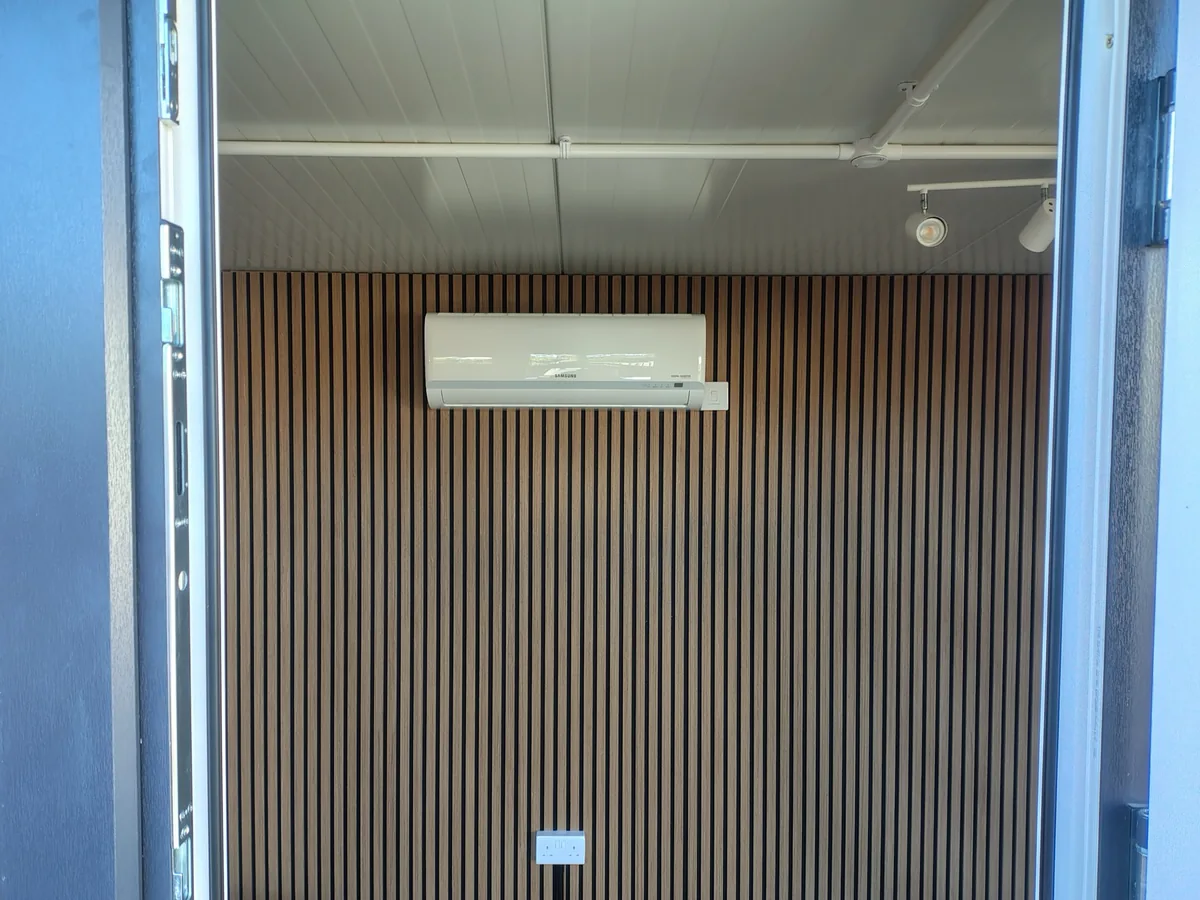 Samsung wall-mounted indoor air conditioning unit on a timber slat feature wall